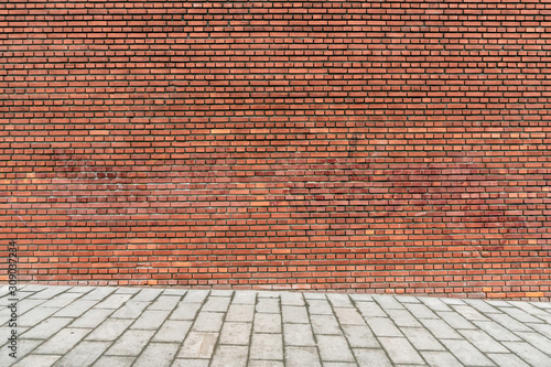 Wall brown brick texture with road. Urban style mockup background. Old brickwall on a street. Pavement and brickwall.