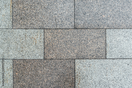 Texture of gray horizontal road granite tiles. Stone background. Modern paving slabs. Motley pattern.