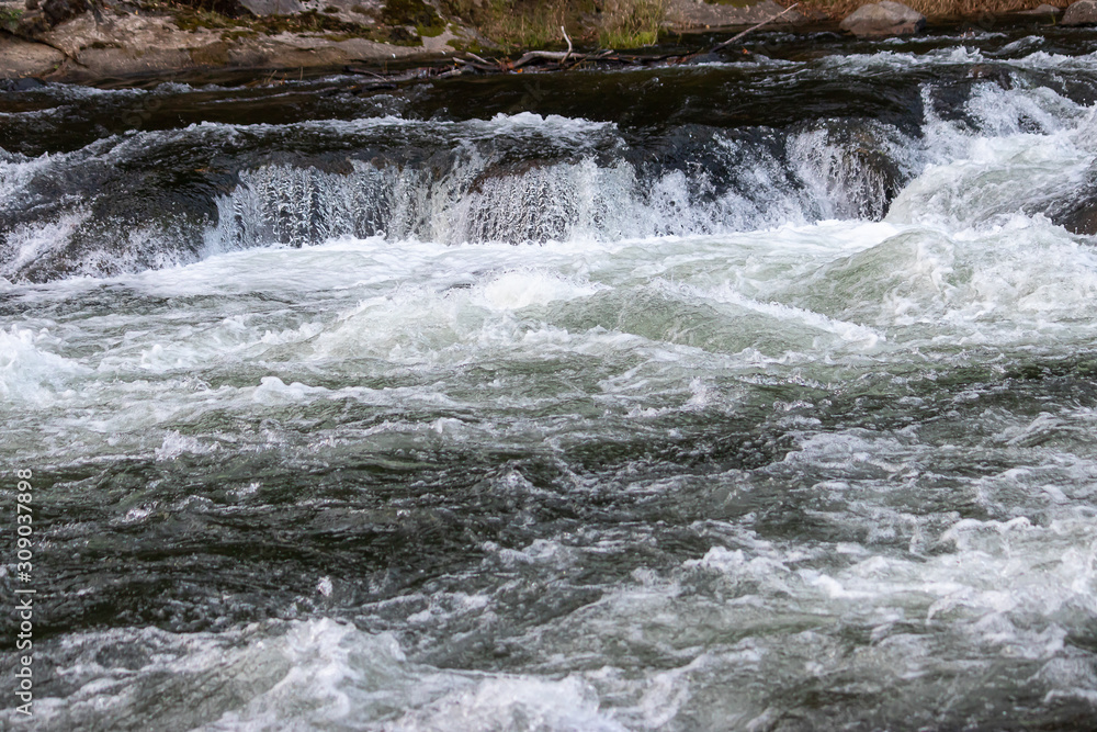 Fototapeta premium small white water fall into rapids on blue river