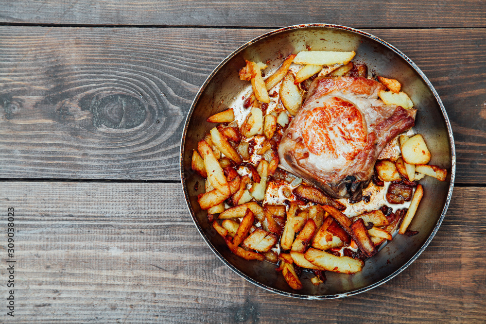 dinner with pan fried meat and potatoes on a table dinner with pan fried meat and potatoes on a table
