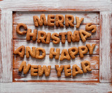 Words Merry Christmas and Happy New Year on a wooden background