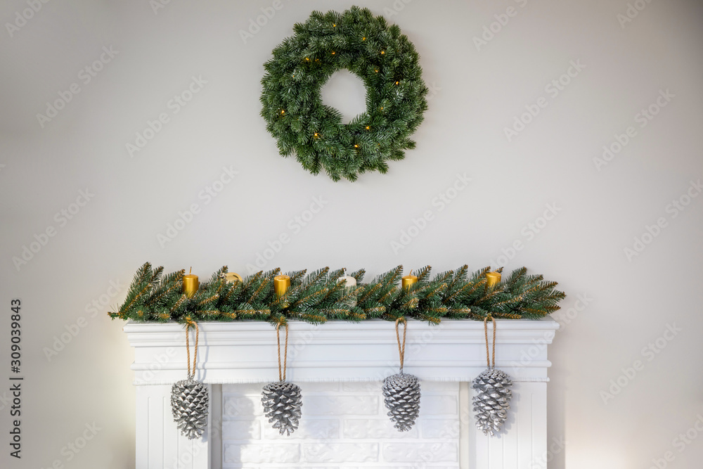 Fototapeta premium Fireplace with beautiful Christmas wreath, decorations in room