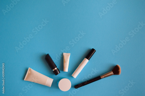Set of cosmetic products on blue color background, flat lay with space for text. White tubes, branding mock up, top view. Beauty blogger, salon treatments concept. Minimalism
