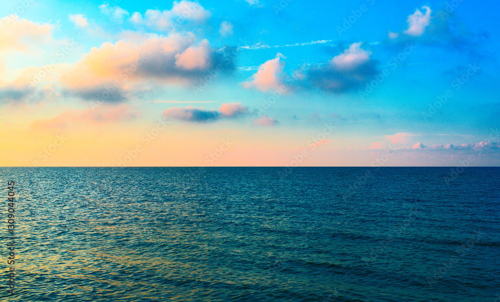 Colorful clouds on the blue surface of the sea.
