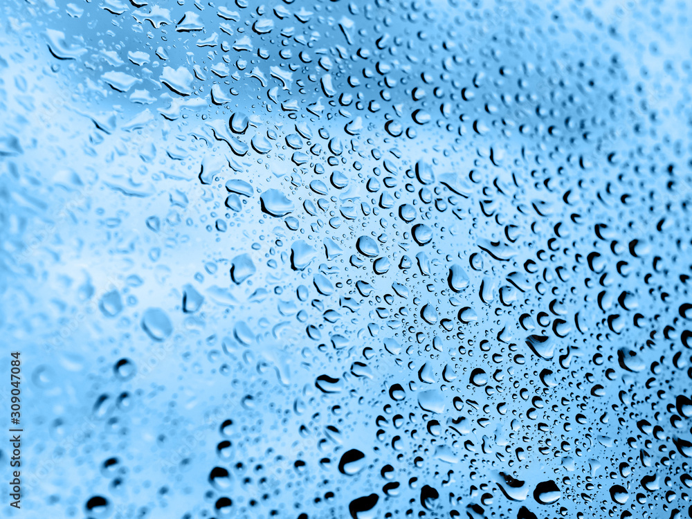 Rain drops on glass. Silhouettes of classic blue water drops on a transparent surface. Rain drops on glass. Silhouettes of classic blue water drops on a transparent surface.