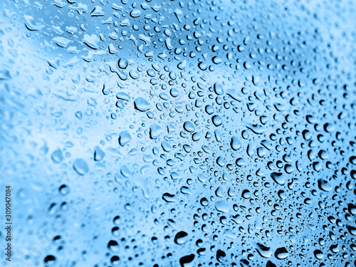 Rain drops on glass. Silhouettes of classic blue water drops on a transparent surface.
