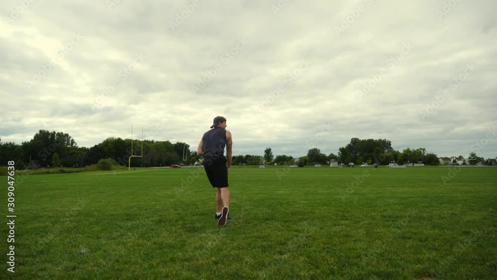 In shape man running on green field, throwing a football, practicing, training, working out and improving in slow motion. In shape man running on green field, throwing a football, practicing, training, working out and improving in slow motion.