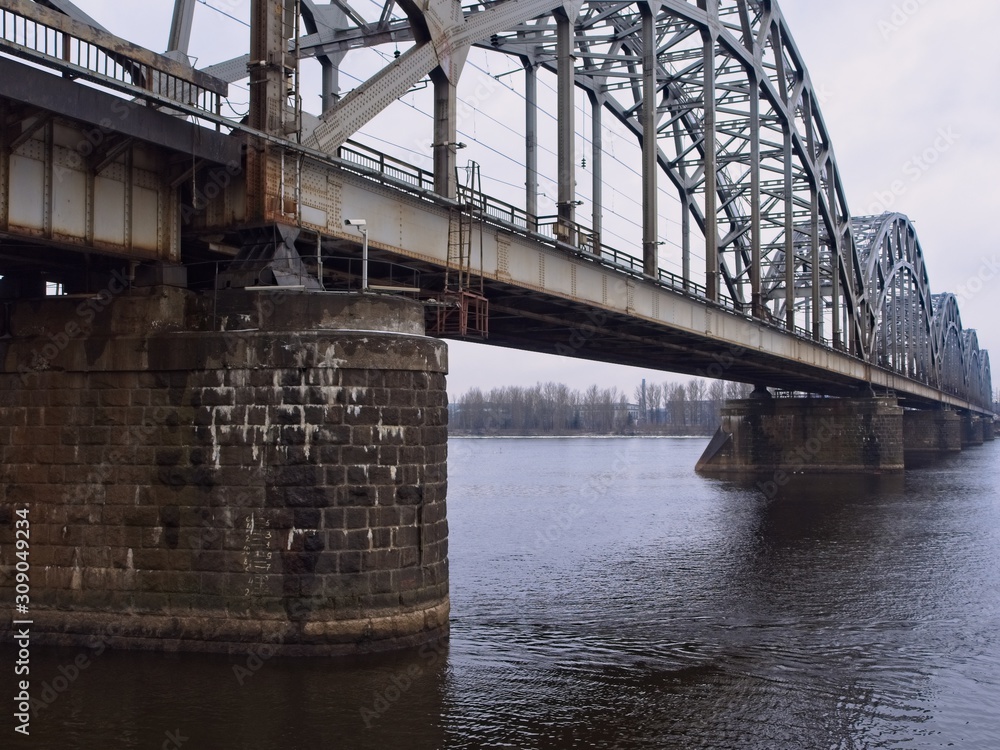 Railroad Bridge over the Daugav River in Riga with a detailed view on the pillar structures on a cold and dull winter day