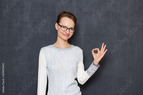 Portrait of happy young woman showing ok gesture or zero with fingers