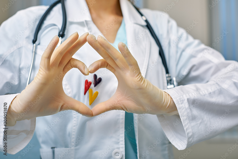 doctor shows simbols of heart through the hands folded in the shape of a heart with medical care concept, Medicine in hospital, cardiology. doctor shows simbols of heart through the hands folded in the shape of a heart with medical care concept, Medicine in hospital, cardiology.