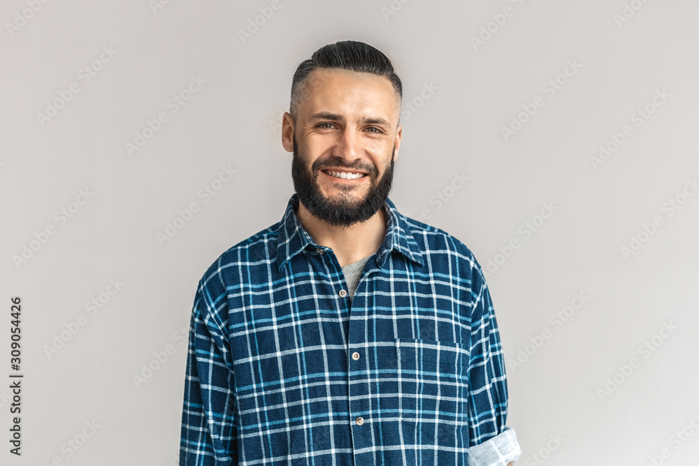 Mature bearded man smiling wide, standing on grey background Mature bearded man smiling wide, standing on grey background