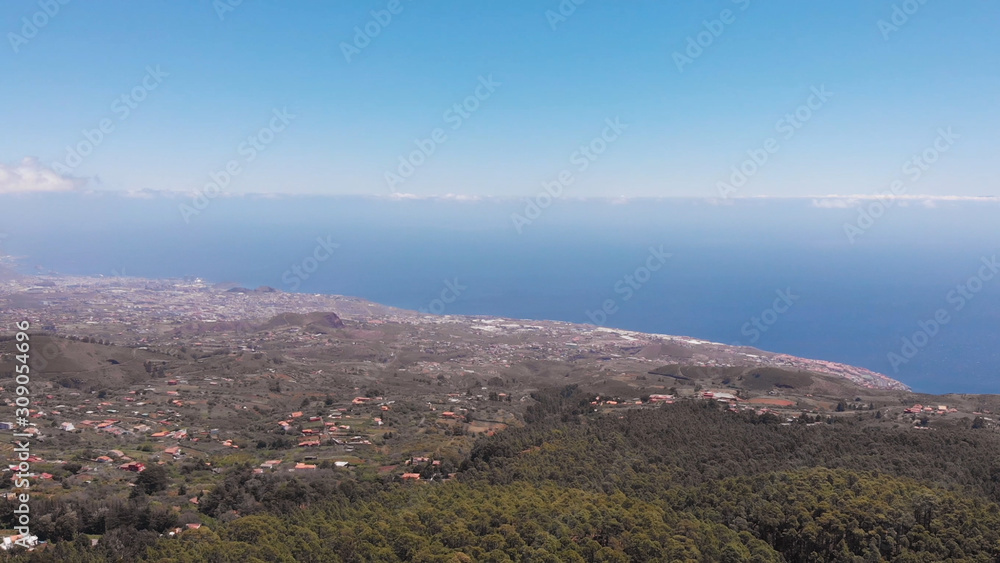 View from the height of the city and off the coast of the Atlantic Ocean and coniferous forest. Evergreen trees, tropical climate. Summer all year round