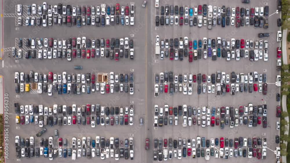 Aerial timelapse of cars driving in busy, crowded parking lot viewed from above Aerial timelapse of cars driving in busy, crowded parking lot viewed from above