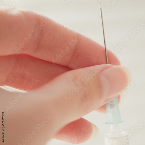 syringe in female hand  macro photo with selective focus