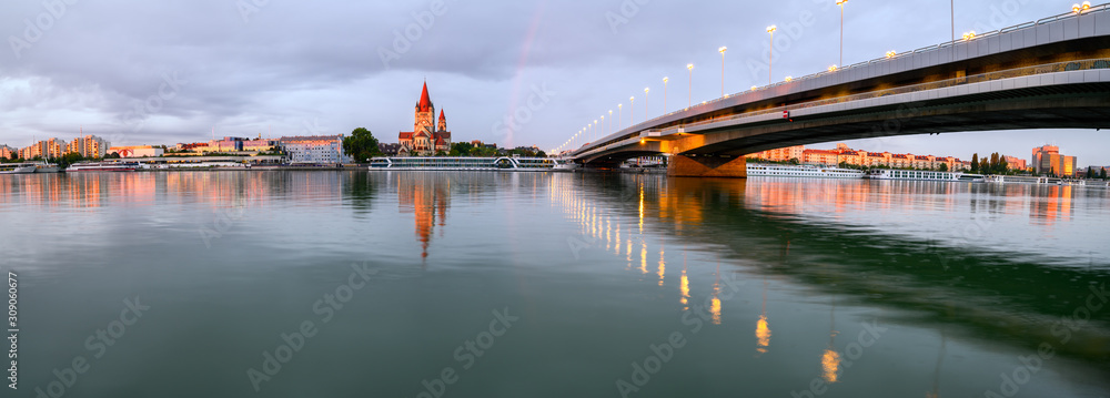 Φωτογραφία Francis of Assisi Church on the Mexikoplatz with the cruise ship on the foreground near the Reichsbrücke bridge, across Danube river in Vienna