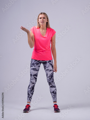 Clueless sport fit women trainer shrugging shoulders looking with confused look don't understand photo