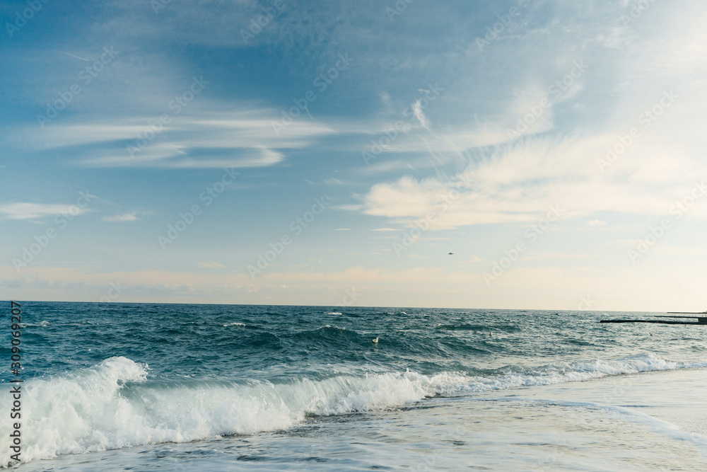 Panoramic view of evening sea with empty beach and waves