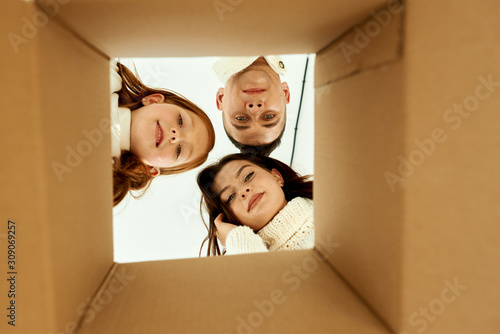 Family unpacking cardboard boxes at new home on a white background