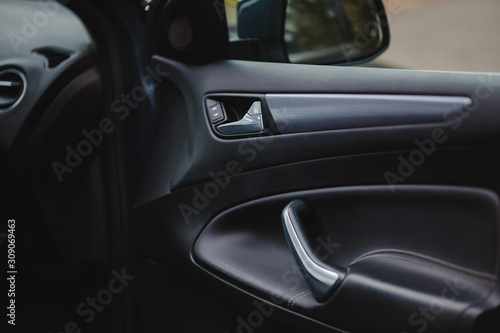 Control panel in the car door. Car door handle with adjustment knobs. © kucheruk