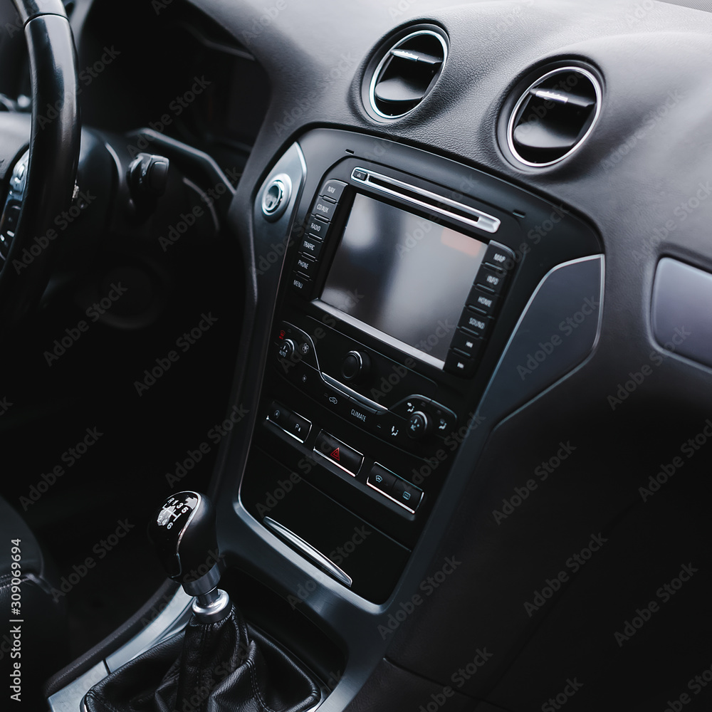 Modern car interior. Steering wheel, gearshift lever, multimedia system, driver's seat and dashboard.