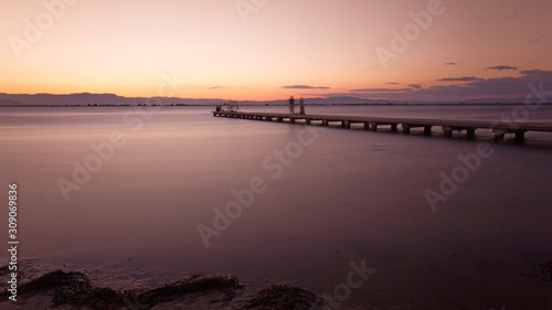 Amazing and peacefull orange sunset with a nice wooden bridge. © Francisco