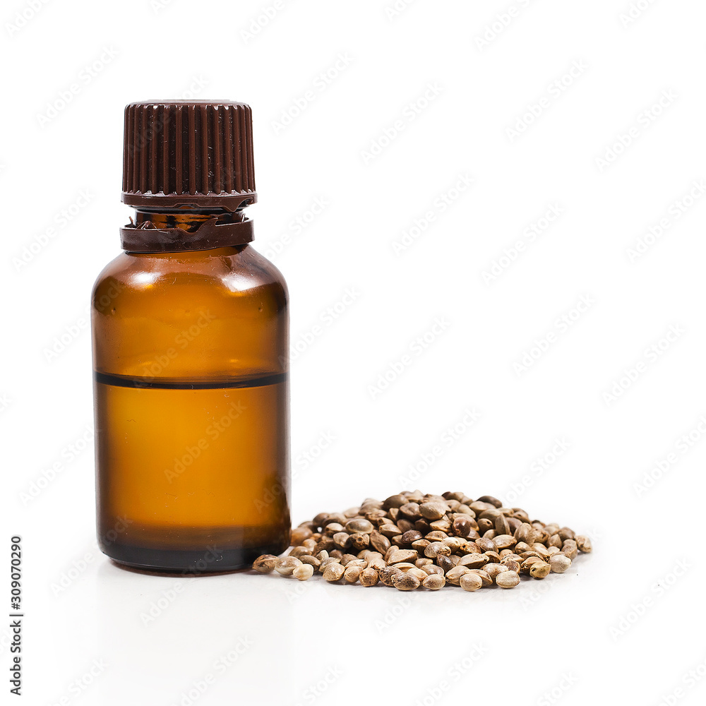 Cannabis seeds and cannabis oil in a glass bottle isolated on a white background. Cannabis seeds and cannabis oil in a glass bottle isolated on a white background.