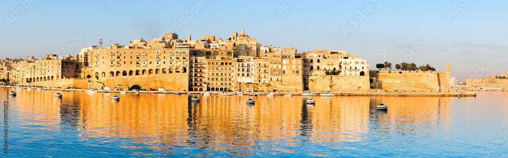 Valetta harbor in the morning, Senglea peninsula in morning light with reflection in calm waters of Grand Valetta Ba, panoramic image
