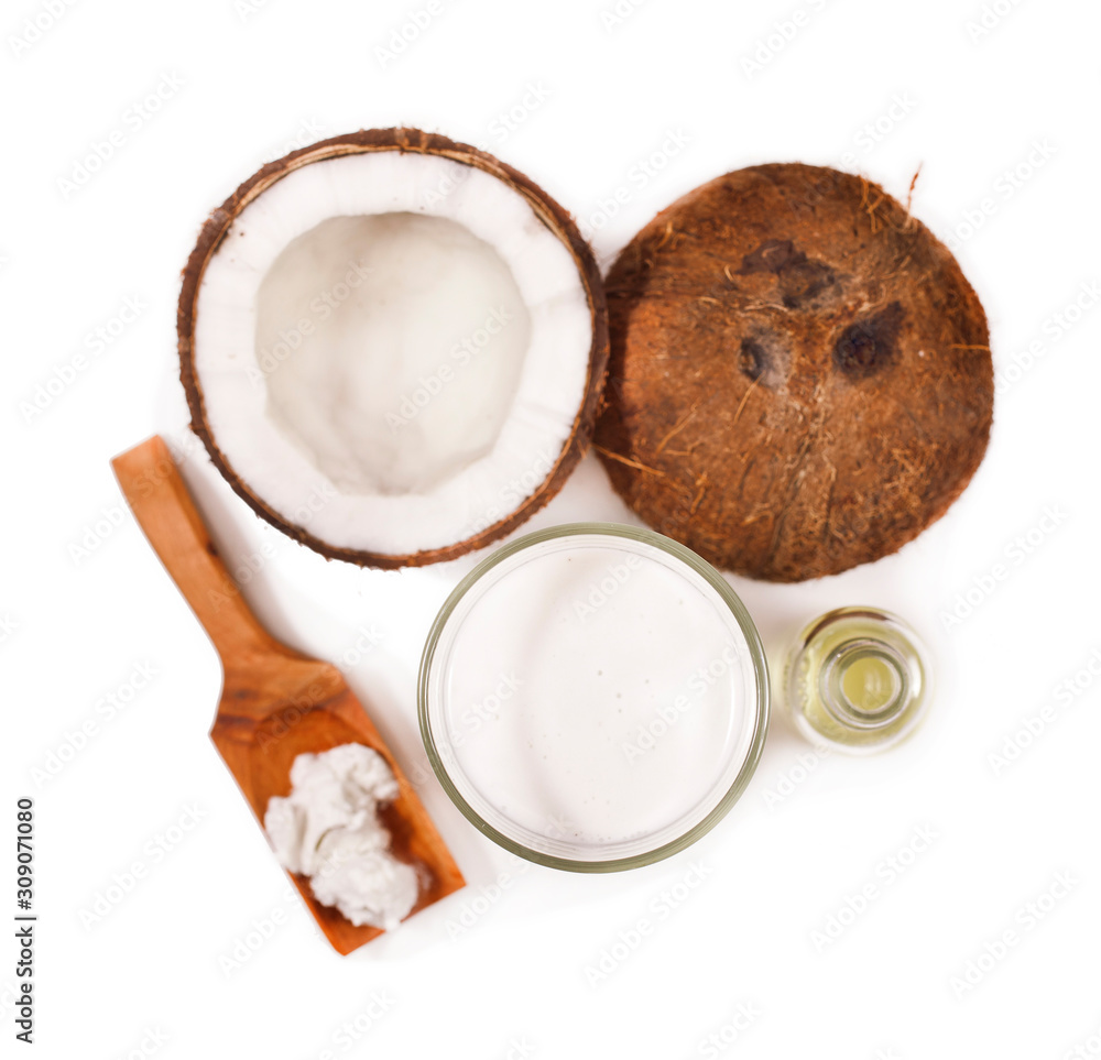 Fresh cracked coconut with coconut milk in a glass and coconut meat in a wooden spoon isolated on white background. Fresh cracked coconut with coconut milk in a glass and coconut meat in a wooden spoon isolated on white background.