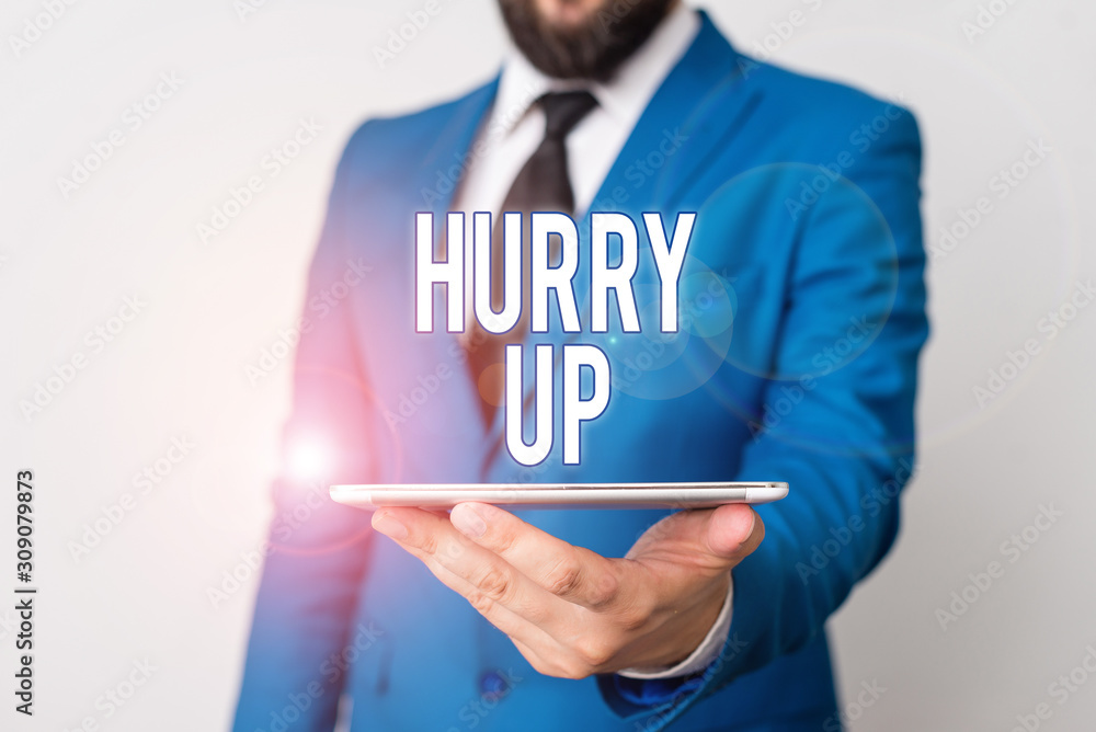 Conceptual hand writing showing Hurry Up. Concept meaning asking someone to do a job very fast Quickly Lets go Encourage Businessman in blue suite with a tie holds lap top in hands Conceptual hand writing showing Hurry Up. Concept meaning asking someone to do a job very fast Quickly Lets go Encourage Businessman in blue suite with a tie holds lap top in hands