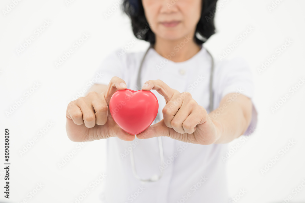 Young woman doctor holding a red heart, standing Young woman doctor holding a red heart, standing