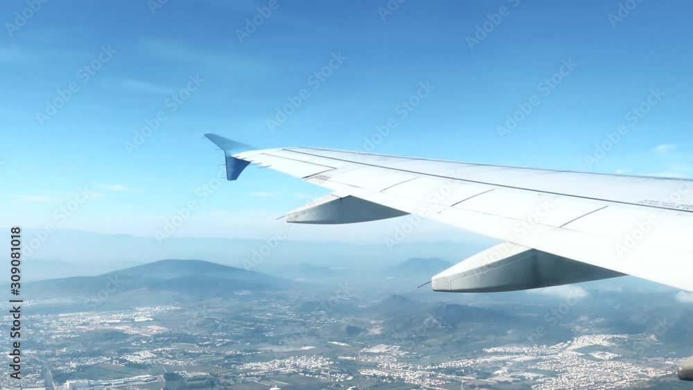 4k View of Airplane Wing Flying Over a city and Mountains in Northern Mexico 4k View of Airplane Wing Flying Over a city and Mountains in Northern Mexico