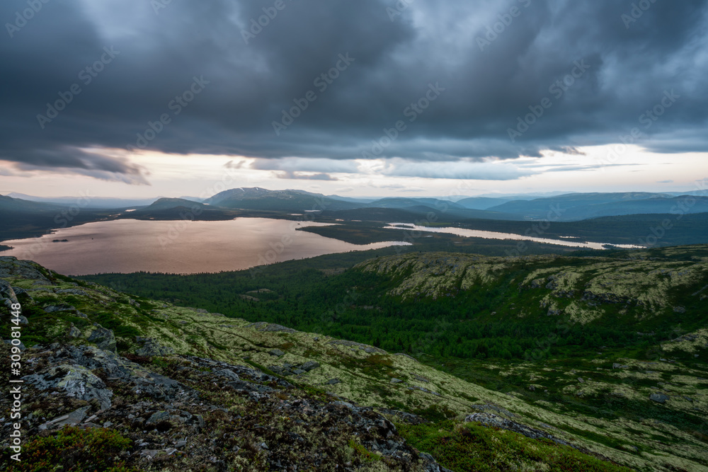 Picturesque scenery of wild landscape scenery with dramatic rain clouds during sunset hours. Hiking and travel concept.