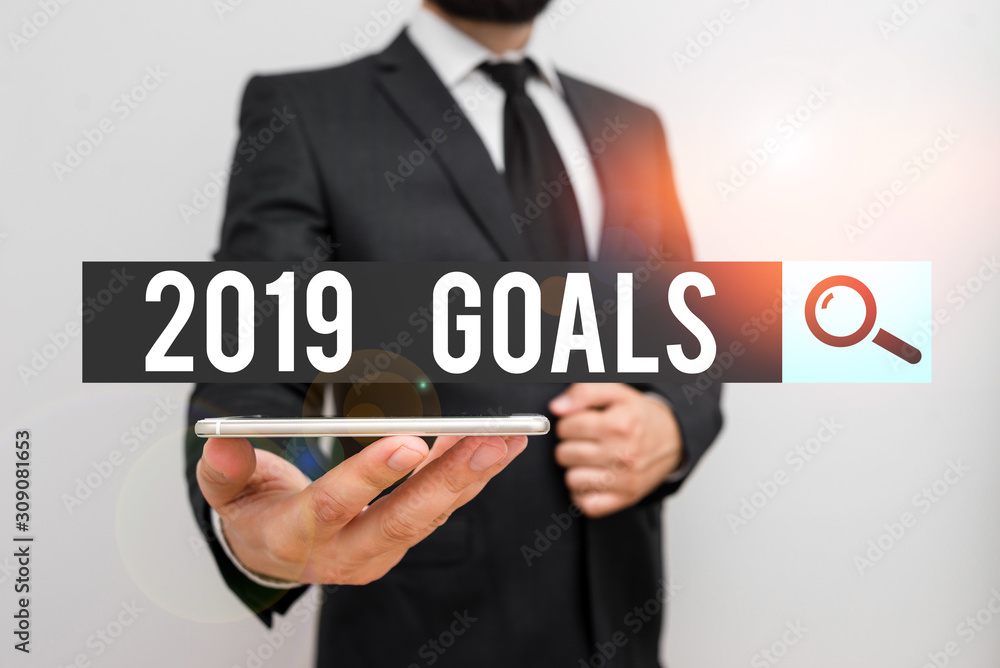 Handwriting text 2019 Goals. Conceptual photo something that you are trying to do or achieve for this year Male human wear formal work suit hold smart hi tech smartphone use one hand Handwriting text 2019 Goals. Conceptual photo something that you are trying to do or achieve for this year Male human wear formal work suit hold smart hi tech smartphone use one hand