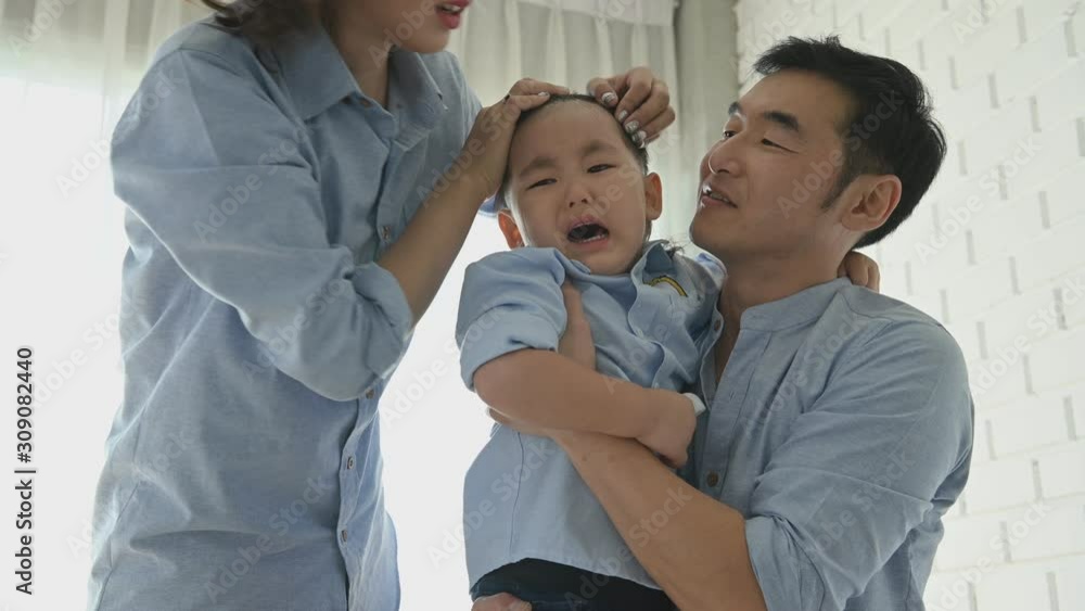 Parents came to comfort half-Japanese boy after slipped and his head hit by floor until he cried. Happy family and baby of Multi-ethnics mixed race people concept. Appreciate parenthood and child Parents came to comfort half-Japanese boy after slipped and his head hit by floor until he cried. Happy family and baby of Multi-ethnics mixed race people concept. Appreciate parenthood and child