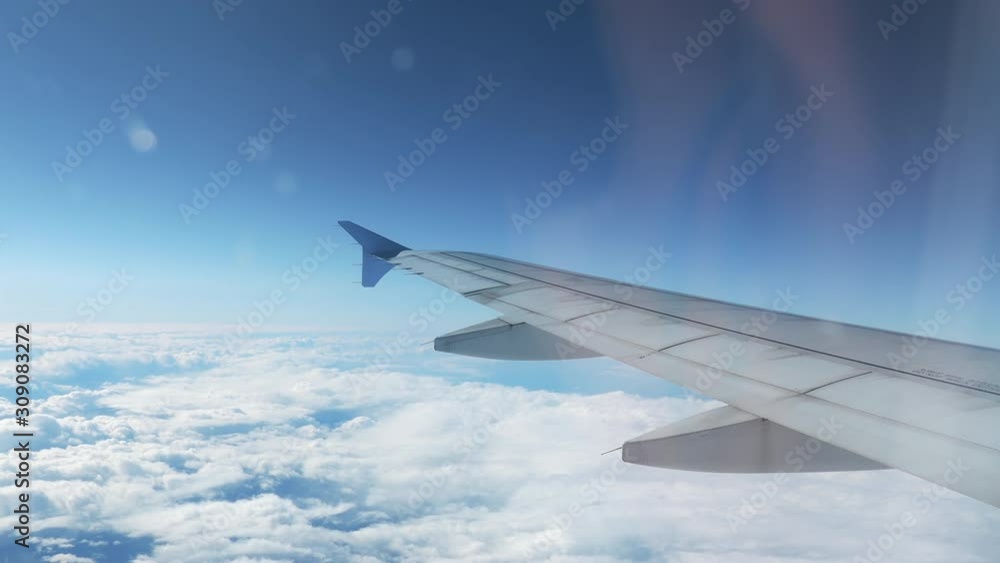 4k Shot of Airplane Wing Flying Over the Clouds with a Blue Sky as Background 4k Shot of Airplane Wing Flying Over the Clouds with a Blue Sky as Background