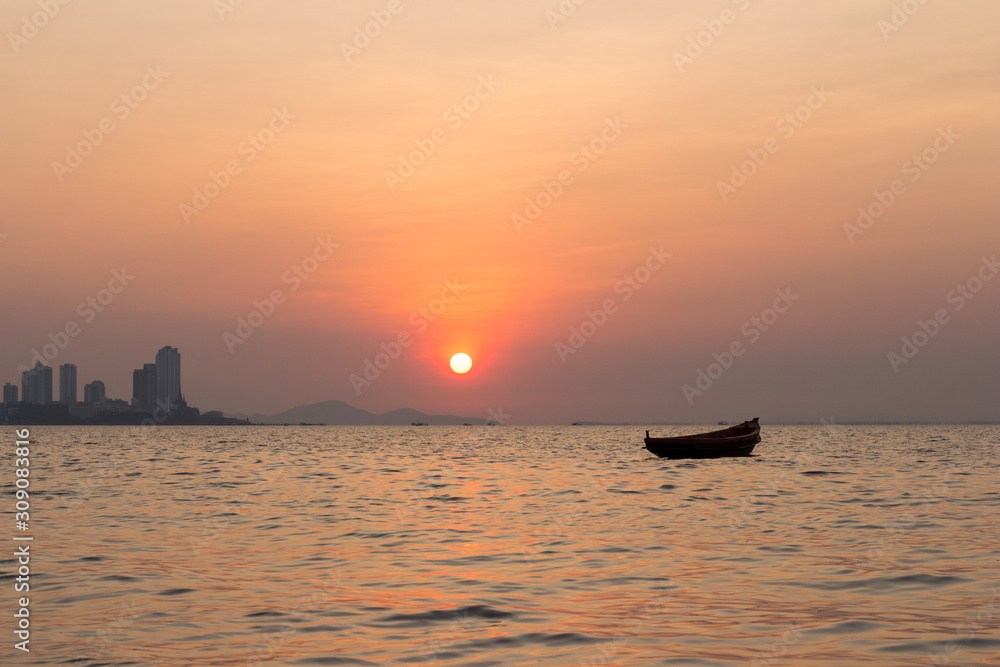 View of the evening sunset. Kathing Lai Beach Banglamung Chonburi province. The light produced is bright red due to dust pollution in the air causing the image to be colored.