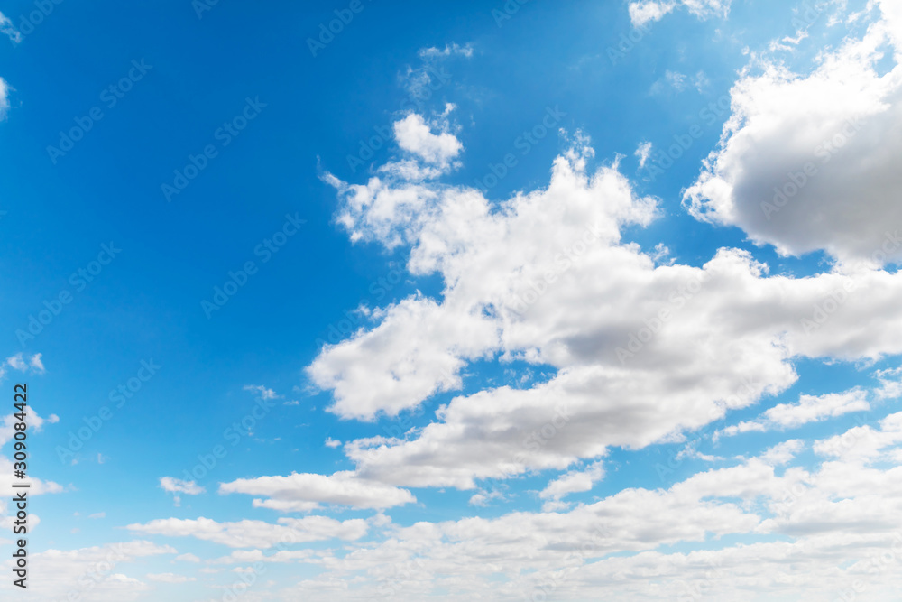 Deep blue sunny sky with white clouds. Blue sky with cloud closeup. White fluffy clouds in the blue sky. Deep blue sunny sky with white clouds. Blue sky with cloud closeup. White fluffy clouds in the blue sky.