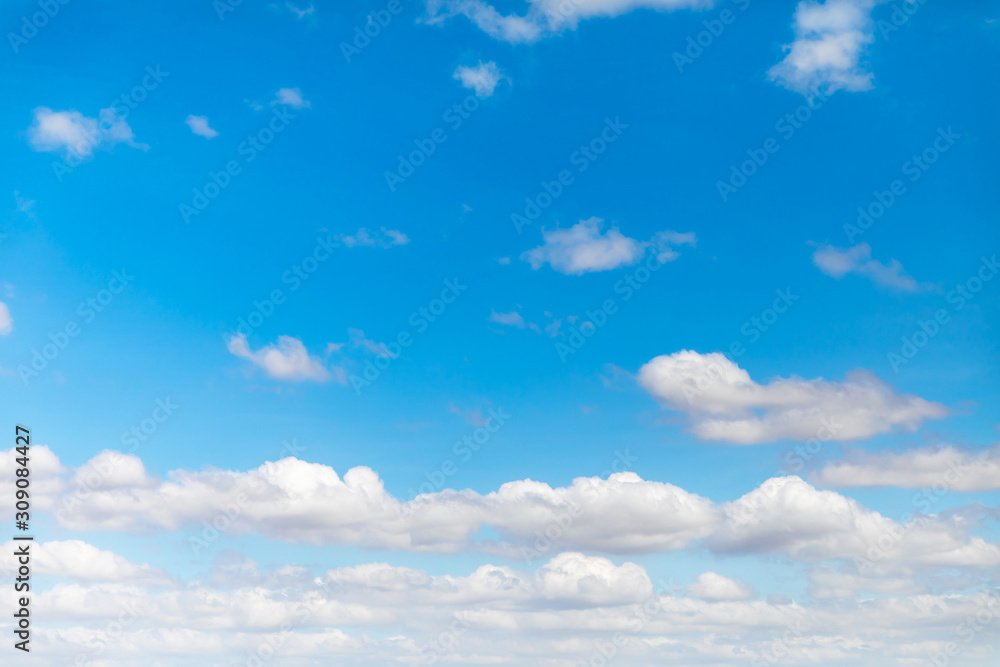 Deep blue sunny sky with white clouds. Blue sky with cloud closeup. White fluffy clouds in the blue sky.