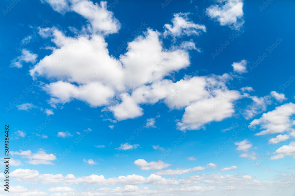 Deep blue sunny sky with white clouds. Blue sky with cloud closeup. White fluffy clouds in the blue sky. Deep blue sunny sky with white clouds. Blue sky with cloud closeup. White fluffy clouds in the blue sky.