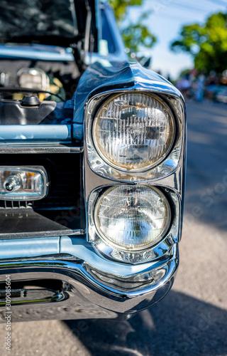 Headlights of an old elegant retro car with an open hood