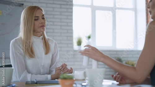 Two women choose cosmetics for purchase in a modern office. care cosmetics concept 4K