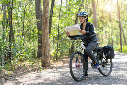 Fototapeta Naklejka Na Ścianę i Meble -  Senior asian woman riding bikes in park with hold and look map on trip