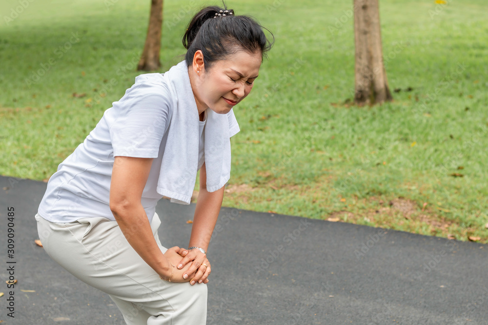 Senior woman Asian leg Pain during running at the park.