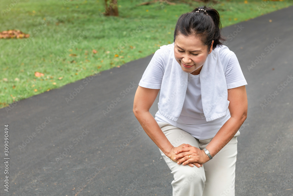 Senior woman Asian leg Pain during running at the park. Senior woman Asian leg Pain during running at the park.
