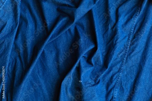 Blue denim fabric with crumpled wrinkles texture background.