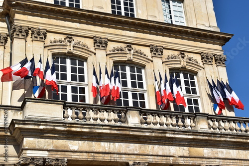 Picture of french flags on a beautiful official building, symbol of a nation facing internal tensions following government reforms. photo