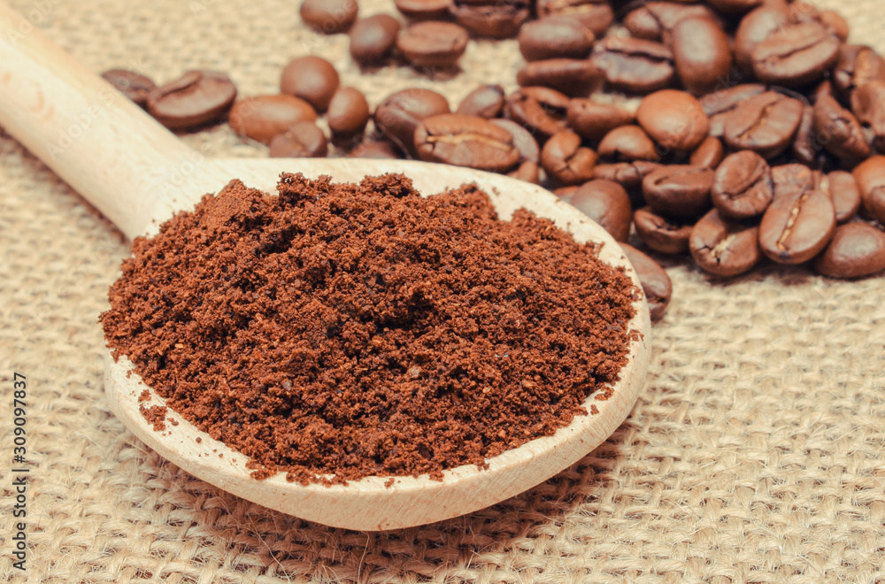 Ground and coffee grains with spoon on jute burlap Ground and coffee grains with spoon on jute burlap