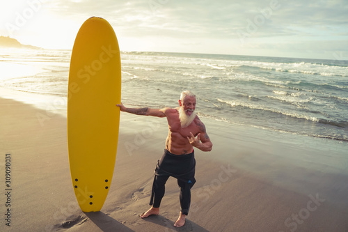 Photography Fit senior having fun surfing at sunset time - Sporty bearded man training with