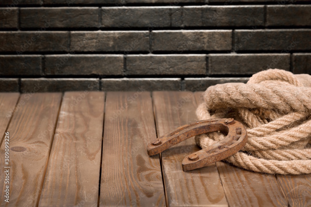 Old horseshoe, lariat lasso and cowboy hat on wooden desk