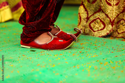 Traditional indian wedding ceremony : Groom puts on  wedding shoes photo